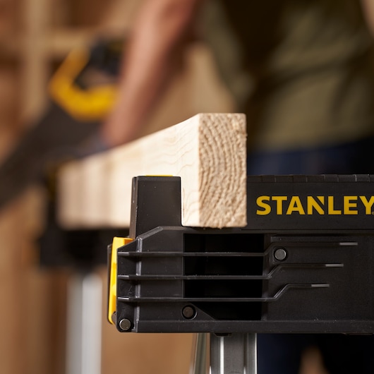 Foto van STANLEY FMST1-75763 zaagbok met houten plank, close-up met zichtbaar logo.