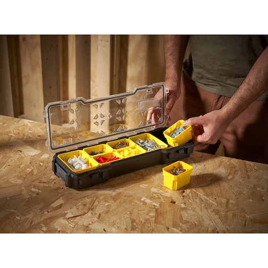 STANLEY FMST1-75781 boîte organisatrice avec bacs jaunes amovibles pour quincaillerie, vue en angle sur l'établi.