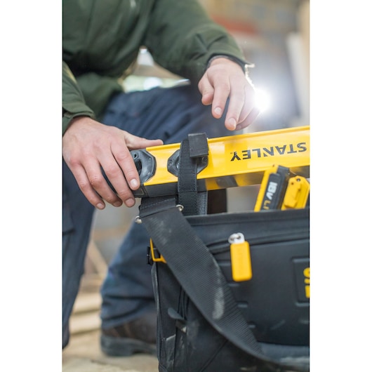 Sac à outils STANLEY FMST1-80146 avec outils et niveau jaune, gros plan, photographie sur chantier.