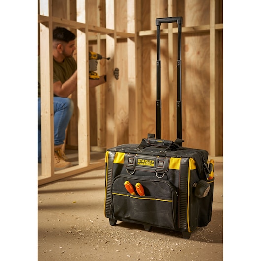 STANLEY FMST1-80148 rollende gereedschapstas met handvat, zwart en geel, op bouwplaats, vooraanzicht.