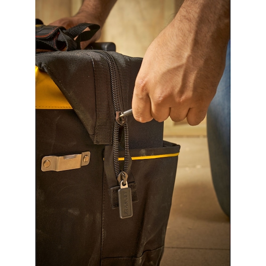 STANLEY FMST1-80148 gereedschapstas met ritsdetail en hand met sleutel, close-up fotografie.