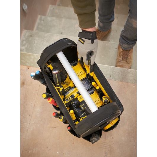 STANLEY FMST17626-1 photographie de sac à outils ouvert avec outils électriques jaunes et outils à main vu de dessus.