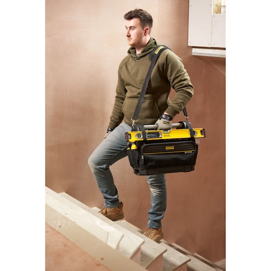 STANLEY FMST17626-1 sac à outils avec outils, porté par une personne sur des escaliers, photo de face.