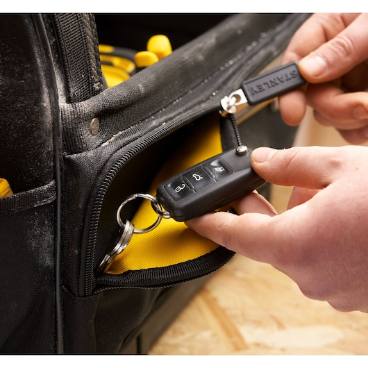 STANLEY FMST17626-1 sac à outils gros plan avec poche zippée, noir avec intérieur jaune, clé et porte-clés visibles.