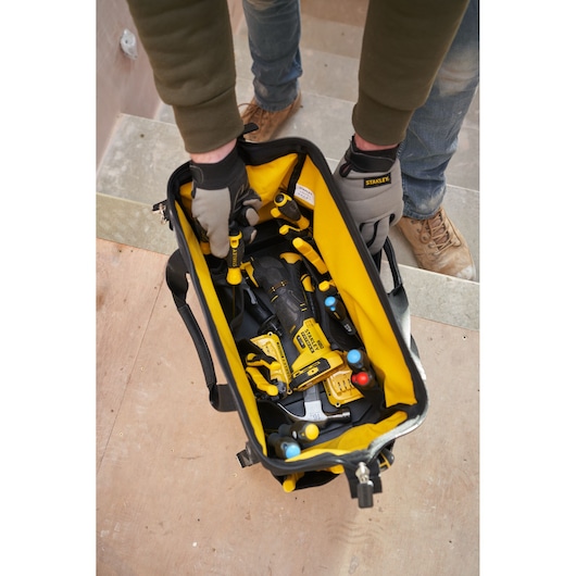 STANLEY FMST17627-1 sac à outils avec intérieur jaune rempli d’outils à main, vue du dessus sur un chantier.