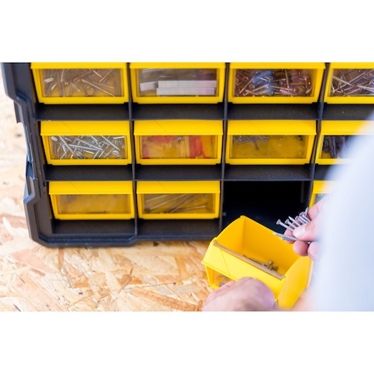 Organisateur STANLEY FMST81077-1 à tiroirs jaunes, rempli de vis et accessoires, vue de face.