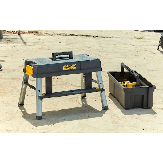 STANLEY FMST81083-1 draagbare werkbank en gereedschapskist buiten, zwart en geel, productfotografie.