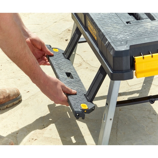 STANLEY FMST81083-1 draagbare werkbank met textuur en afneembare steun, buitenomgeving.