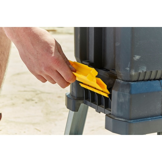 STANLEY FMST81083-1 gereedschapskist gele sluiting detail vastgehouden door hand, zijaanzicht foto.