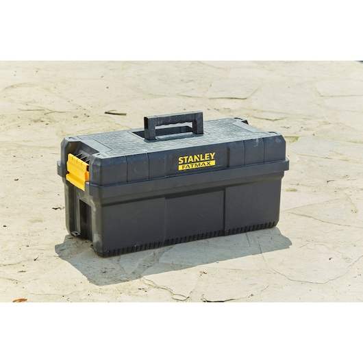 STANLEY FMST81083-1 gereedschapskist van zwart plastic met gele sluitingen, buitenfotografie.