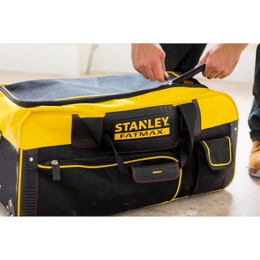 STANLEY FMST82706-1 grote geel-zwarte zachte gereedschapstas met rits, geopend met de hand.