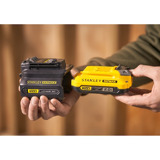 Foto van STANLEY SFMCB100 V20 FATMAX lithium-ion batterijen, zwart en geel, in handen gehouden.