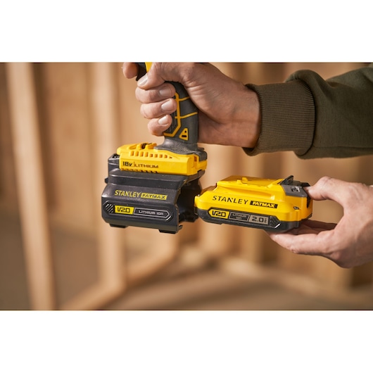 Foto van STANLEY FATMAX V20 lithium-ion batterijen, SKU SFMCB100, die aan een elektrisch gereedschap worden bevestigd.