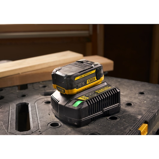 Stanley SFMCB206 lithium-ion batterij en oplader op een werkbank, foto vanaf de voorzijde genomen.