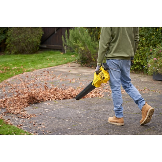 STANLEY SFMCBL714M1 bladblazer gebruikt om bladeren op terras te verwijderen, buitenomgeving, zijaanzicht.