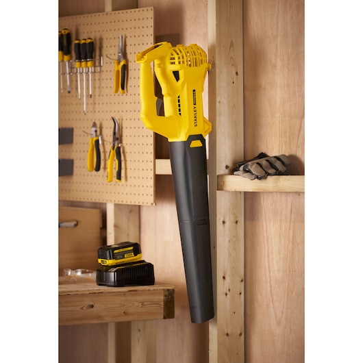 STANLEY SFMCBL714M1 draadloze bladblazer met accu in een werkplaats, zijaanzicht.