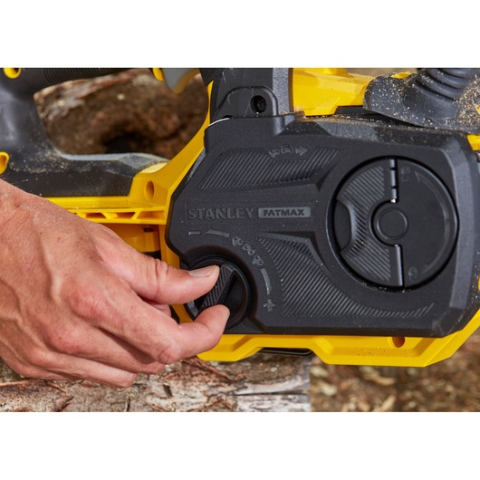 Photo du panneau de commande de la tronçonneuse STANLEY SFMCCS630M1 avec main ajustant le bouton, angle rapproché.
