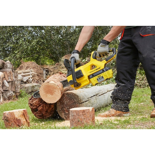 Photo de tronçonneuse STANLEY SFMCCSB664B coupant une bûche en extérieur, vue rapprochée en action.