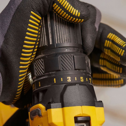 STANLEY SFMCD700C2K perceuse en action, vue latérale, gant noir et jaune réglant le couple.