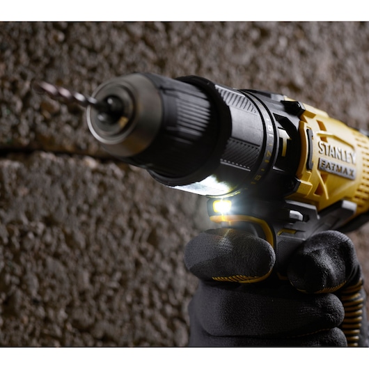 STANLEY SFMCD711C2S draadloze boormachine met LED-licht, close-up zijaanzicht, zwart-gele uitvoering, in gebruik.