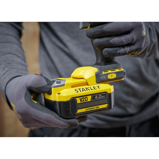 Stanley V20 snoerloos gereedschap met 4.0Ah lithium-ion batterij in gehandschoende handen.
