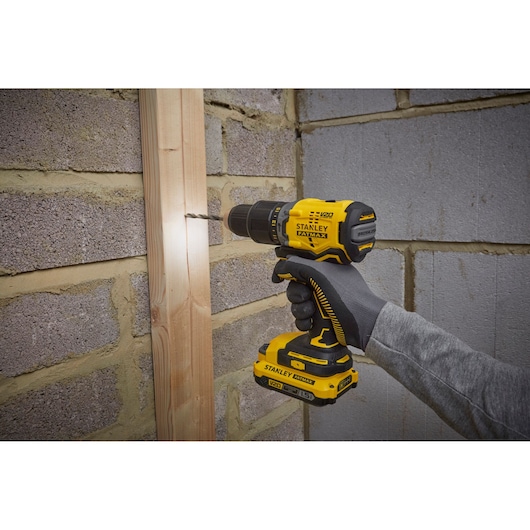 STANLEY SFMCD715C2K draadloze boormachine in gebruik op hout, geel-zwarte uitvoering, handgereedschap.
