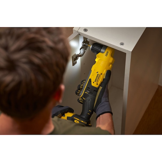 STANLEY SFMCD750D2K draadloze boormachine gebruikt op kastscharnier, ergonomische grip gefotografeerd.
