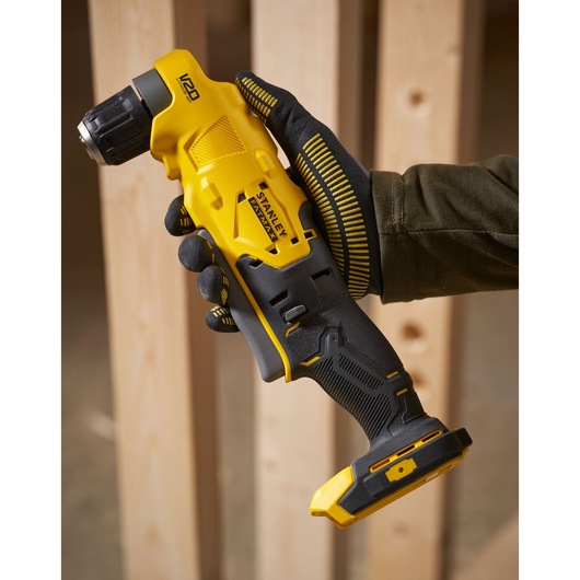 STANLEY SFMCD750D2K snoerloze hoekkop boormachine vastgehouden in een gehandschoende hand, geel en zwart ontwerp close-up.