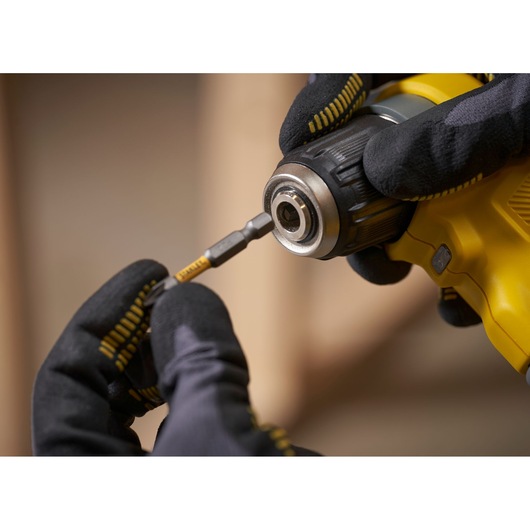 STANLEY SFMCD750D2K boormachine in gebruik, close-up van bit plaatsen, zwarte handschoenen.