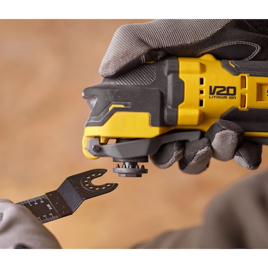STANLEY SFMCE510B oscillerend gereedschap close-up met handschoen die een blad bevestigt.