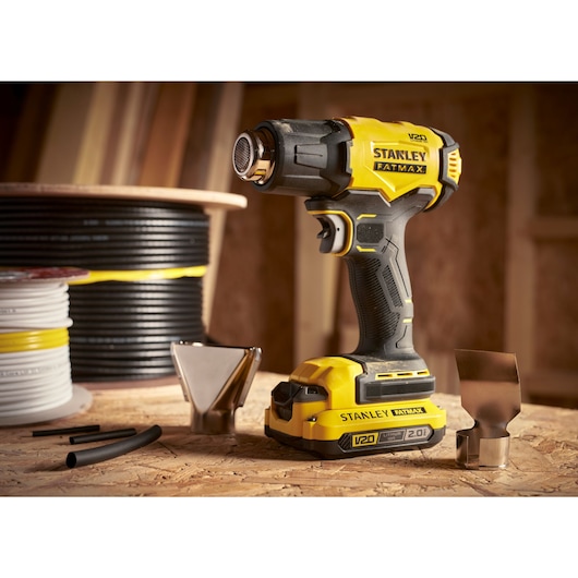 STANLEY SFMCE530B pistolet thermique avec accessoires, jaune et noir, photographie du produit sur table d’atelier.
