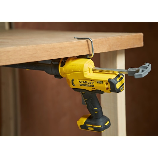 Scie sabre sans fil STANLEY SFMCE600B fixée à une table en bois, vue latérale.