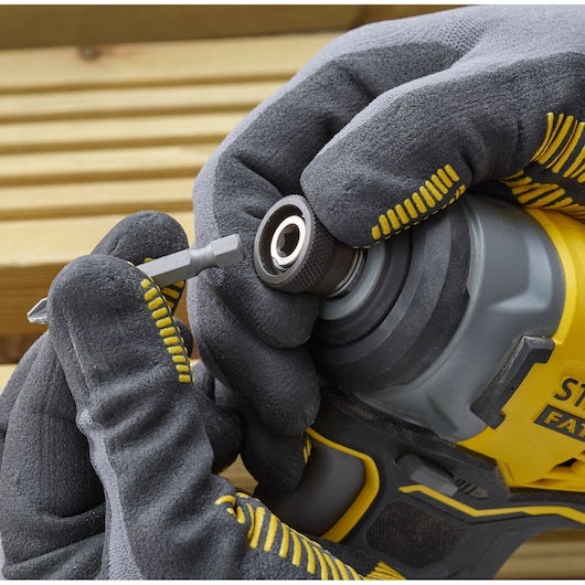 STANLEY SFMCF810D2K visseuse à choc en gros plan, main gantée insérant un embout