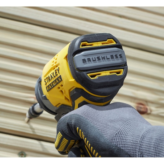 STANLEY SFMCF820D2K slagschroevendraaier, brushless, close-up in gebruik, geel-zwart omhulsel.
