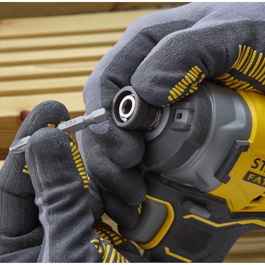 STANLEY SFMCF820D2K slagschroevendraaier vooraanzicht, gehandschoende hand plaatst bit