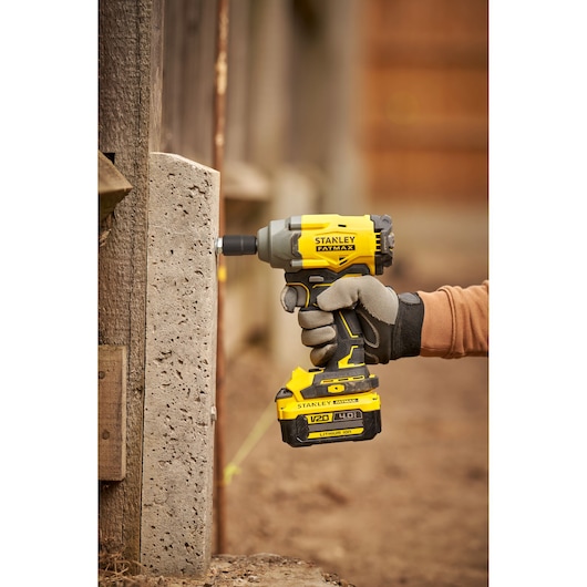 STANLEY SFMCF920B boulonneuse en utilisation, jaune et noire, gros plan extérieur, catégorie photographie.
