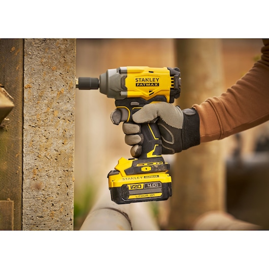 Stanley SFMCF920B visseuse à choc sans fil en fonctionnement, design jaune et noir, tenue par un ouvrier.