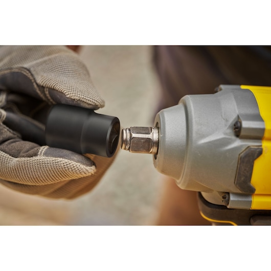 STANLEY SFMCF920B photographie, gros plan de clé à choc avec main gantée tenant un embout de douille.