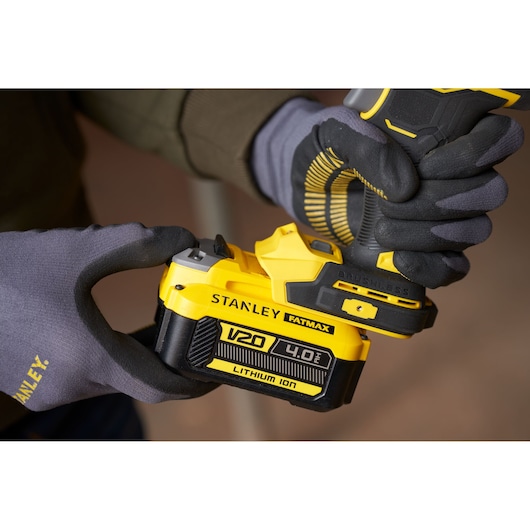 Foto van STANLEY SFMCF940M1 snoerloze boor met V20 4.0Ah lithium-ion accu, vastgehouden met handschoenen.