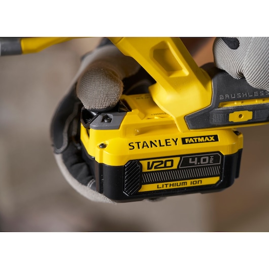Foto van STANLEY SFMCH900B V20 4.0Ah Lithium Ion batterij op geel elektrisch gereedschap, close-up.