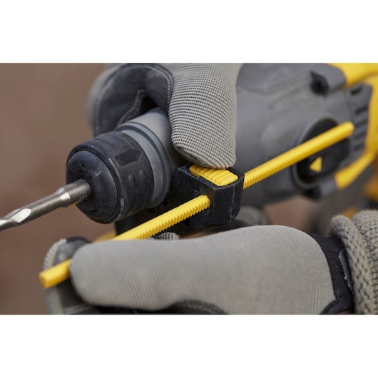 STANLEY SFMCH900B boorhamer close-up, gehandschoende hand stelt gele dieptestop af, zijaanzicht.