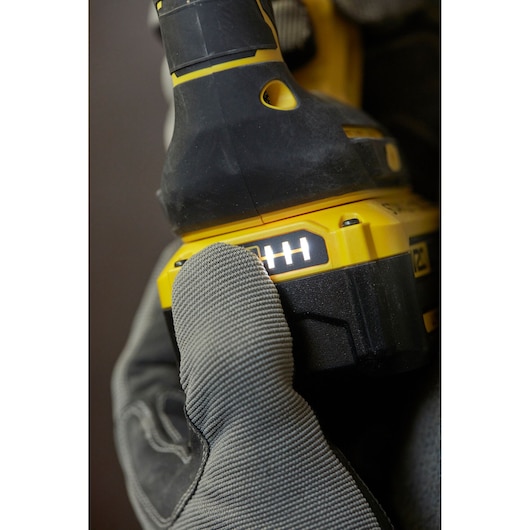 STANLEY SFMCH900M22 accuboormachine energie-indicator close-up vastgehouden door gehandschoende hand, zijaanzicht.
