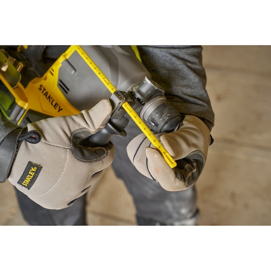 Foto van STANLEY SFMCH910R1T boorhamer met dieptestop, werknemer stelt het gereedschap af.