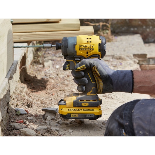 Stanley SFMCK461D2S accu slagschroevendraaier in gebruik buiten met handschoen, boort in hout.