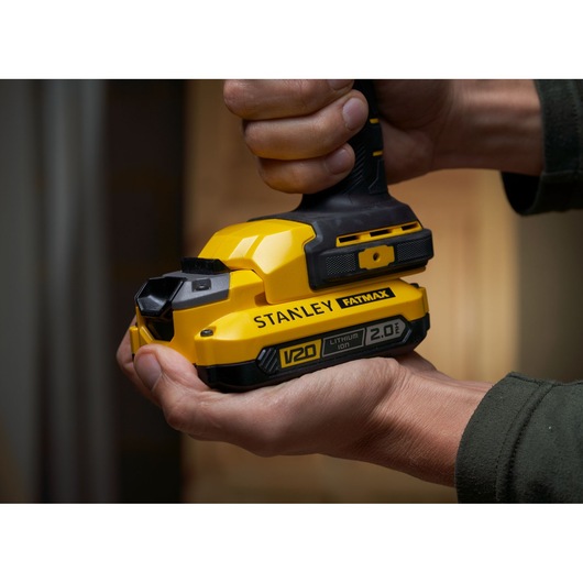 STANLEY SFMCL050B 18V FATMAX V20 Pivot Light, geel, close-up in hand.