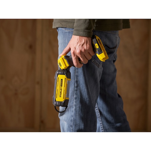 STANLEY SFMCL050B 18V FATMAX V20 pivot light in hand, geel en zwart, fotografieproduct.