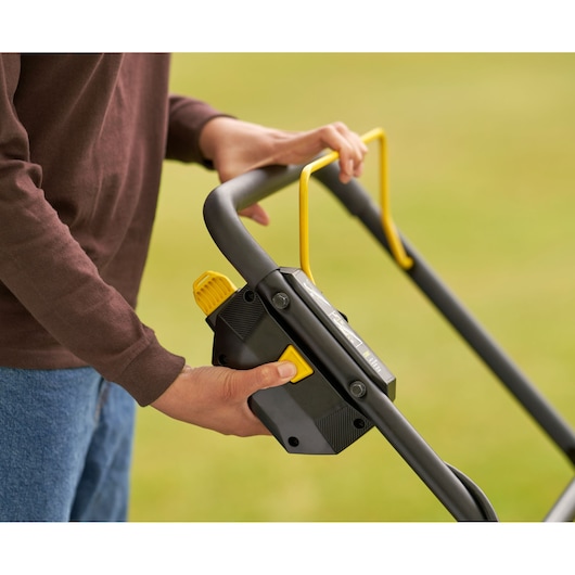 STANLEY SFMCMW2651M close-up van grasmaaierhandgreep met gele hendel en knoppen buiten.