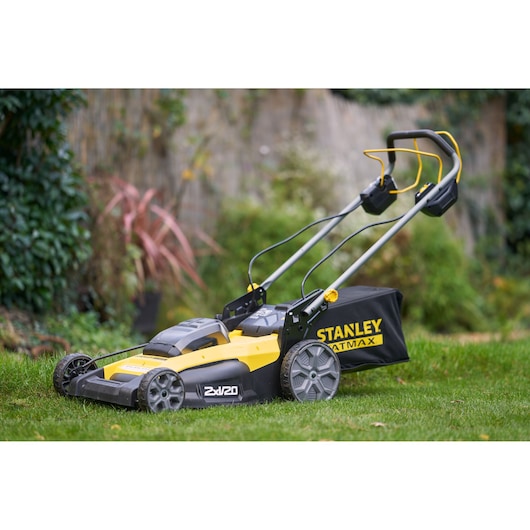 STANLEY SFMCMWS251B grasmaaier, geel en zwart, zijaanzicht, op gras buiten.