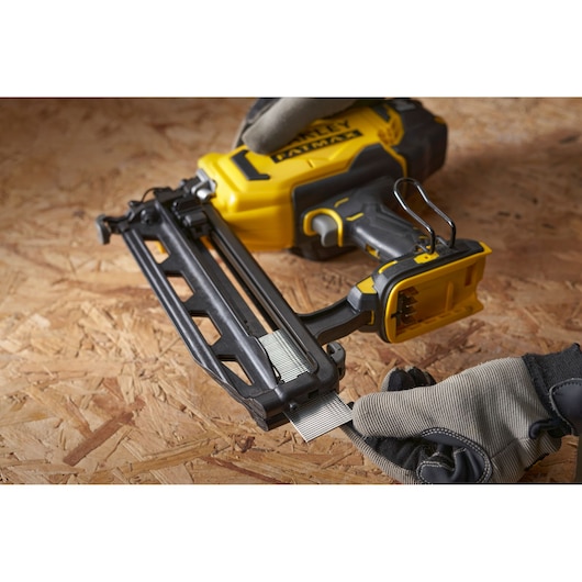 STANLEY SFMCN616B nagelmachine, geel en zwart, schuin aanzicht, geladen met spijkers op houten oppervlak.