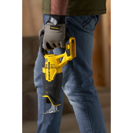 STANLEY SFMCS300B scie sabre tenue par un ouvrier en gants, jaune et noir, vue latérale du produit.